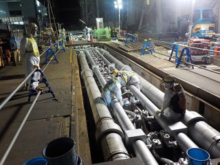 Readying refrigeration lines at Fukushima to create a 30-meter-deep frozen barrier against groundwater